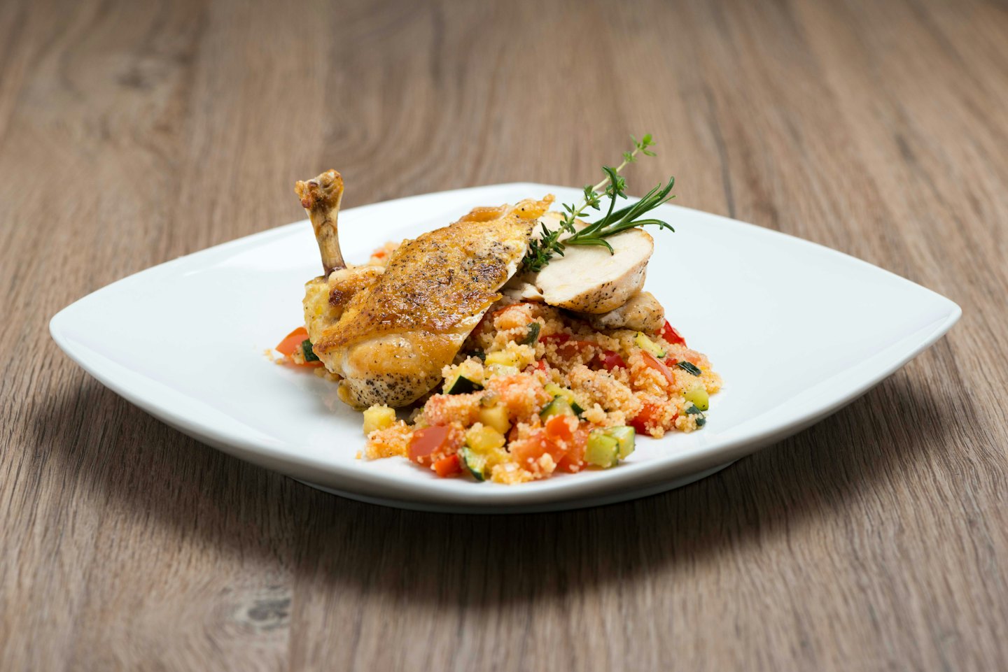 Roasted chicken with vegetables on a white plate.