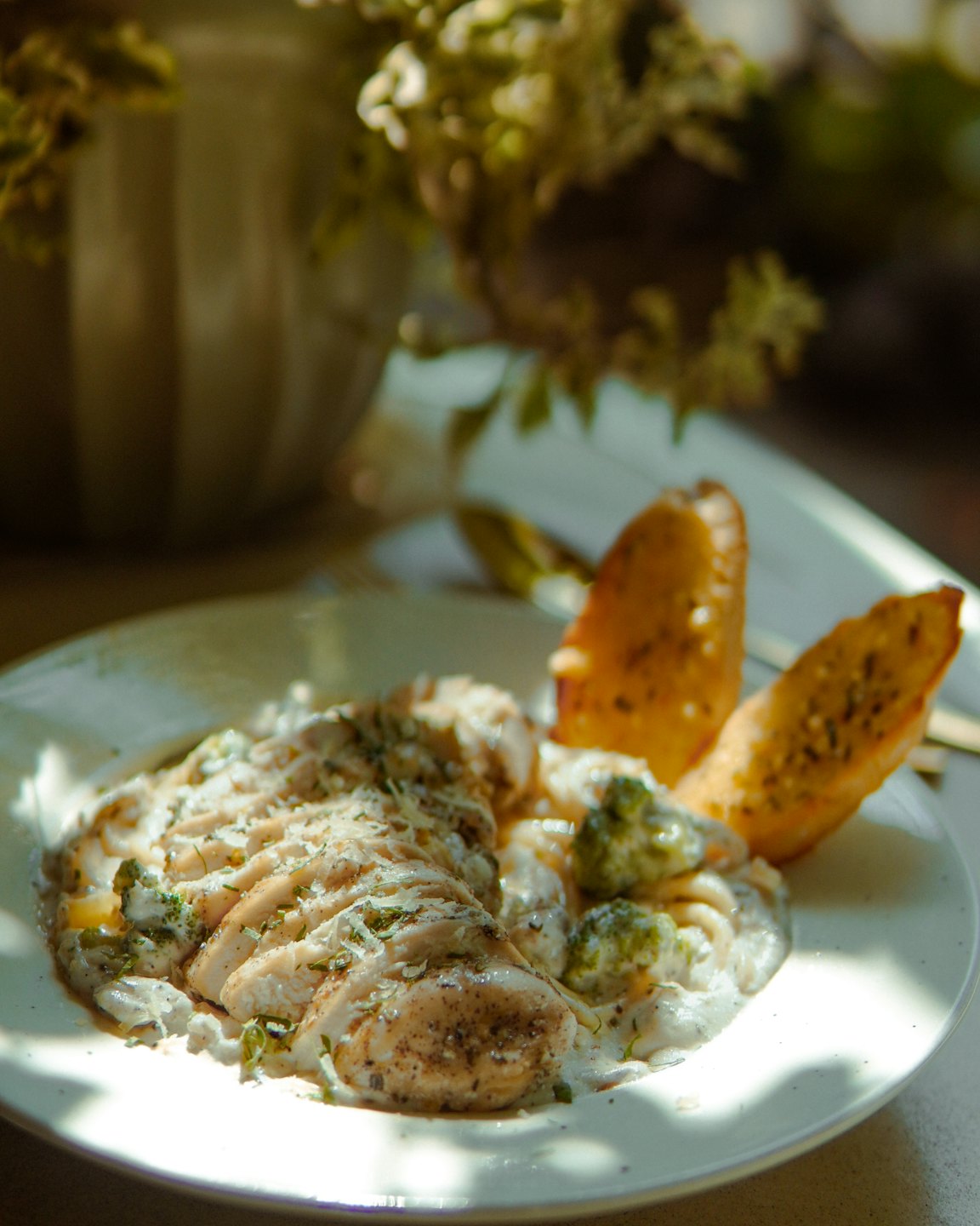 Sliced chicken breast with broccoli and toast on a plate.